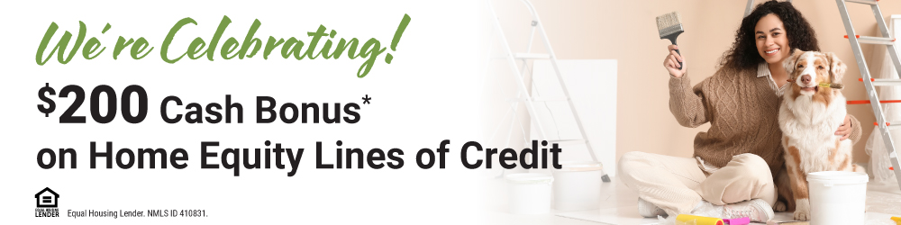 woman smiling holding a paint brush preparing to paint a wall with her dog beside her. We're celebra…