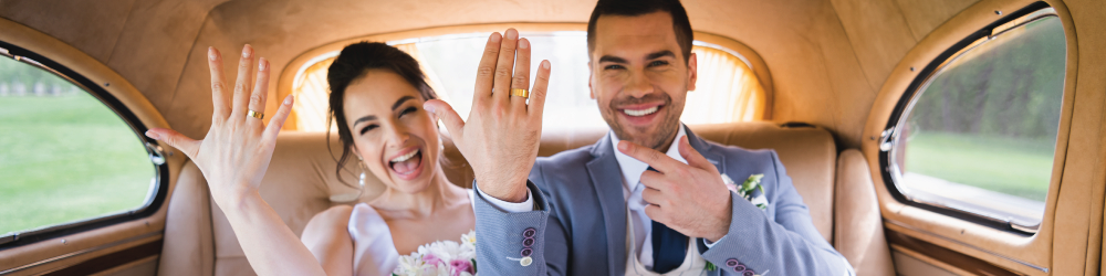smiling couple just married in back seat of car
