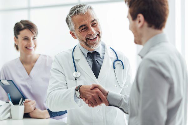 doctor and nurse shaking patients hand smiling