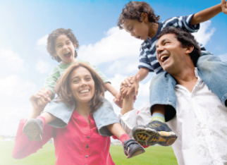 family in a field laughing
