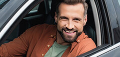Man smiling out of car window