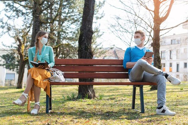 two people sitting on a bench far apart